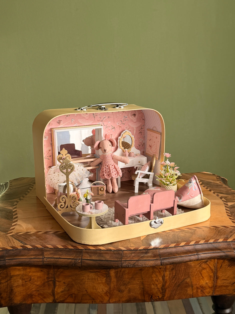 Tiny Ballerina medium suitcase dollhouse open on a wooden table, with ballet studio, vanity table and pink theatre seats