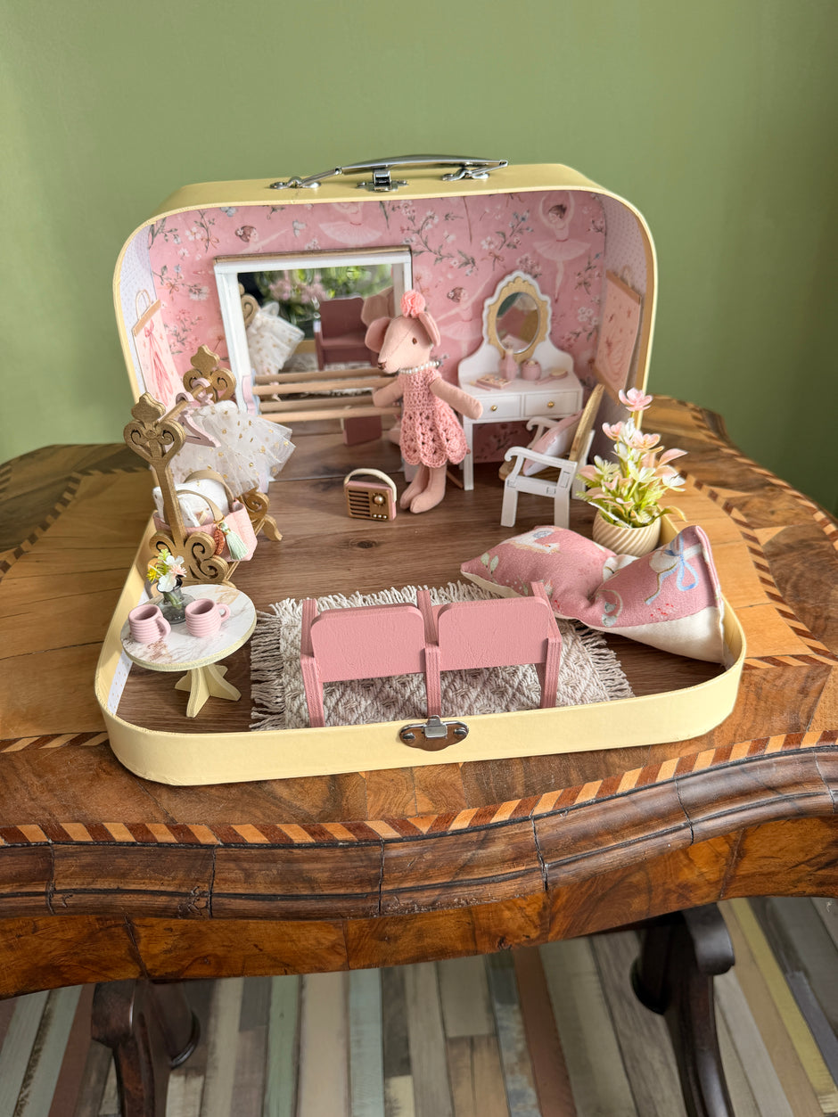 Front view of the Tiny Ballerina suitcase dollhouse with dance studio, vanity and pink theatre seats