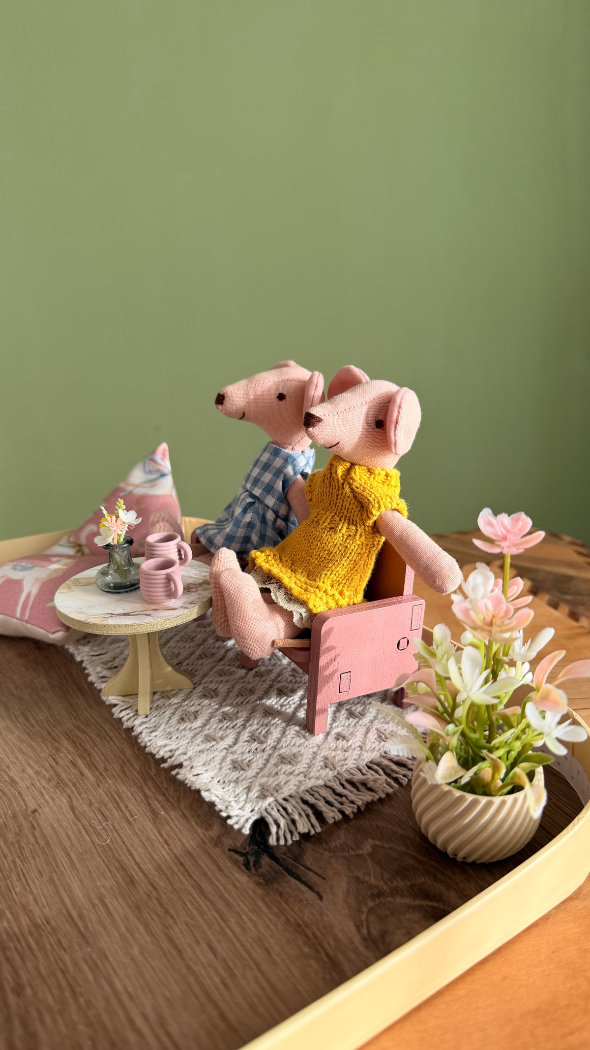 Two mouse dolls sitting in the pink theatre seats of the ballerina suitcase dollhouse
