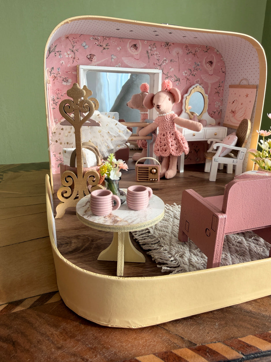 Gold coat stand with tutu, ballerina mouse, tiny radio and a table with pink cups inside the ballerina suitcase