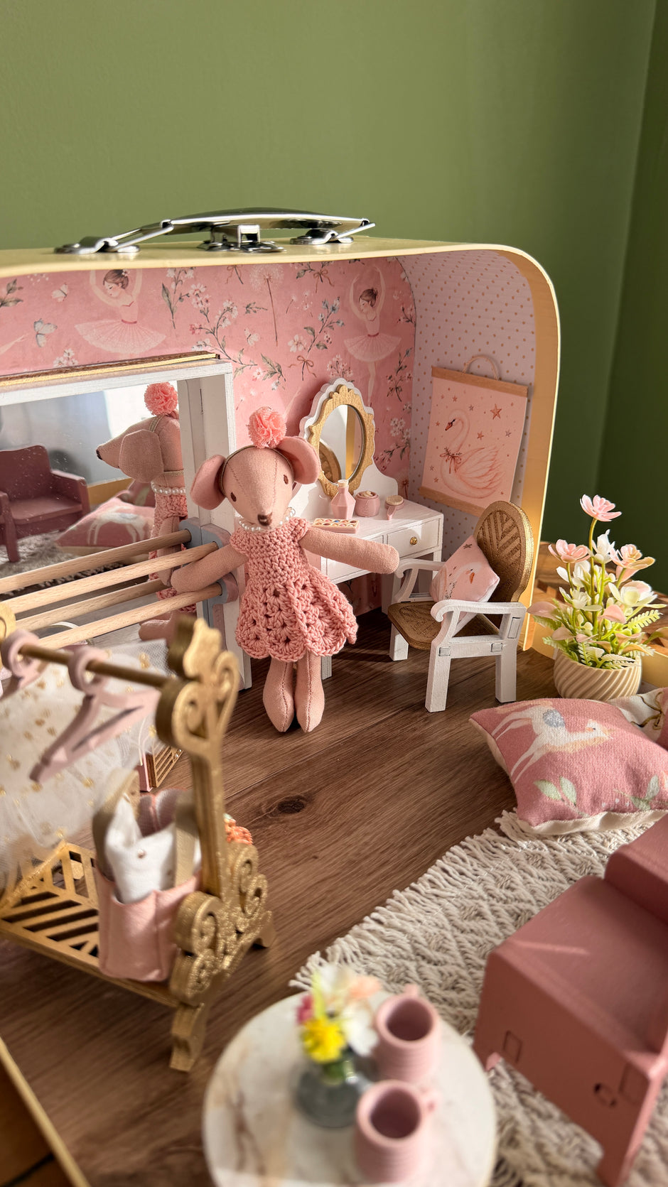 Ballerina mouse practising at the wooden ballet barre in front of the mirror inside the suitcase dollhouse