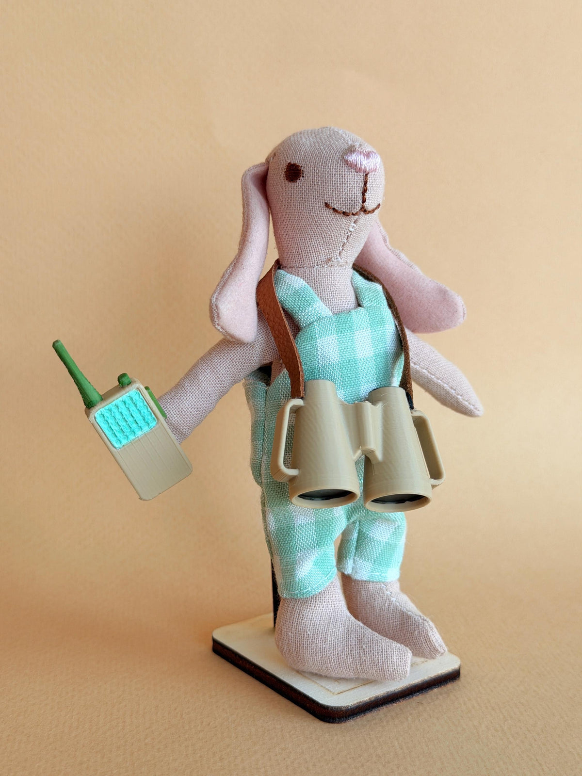 Benjamin, a handmade fabric rabbit doll in mint overalls with tiny binoculars and a walkie-talkie